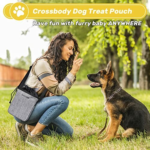 Woman using crossbody dog treat pouch with German Shepherd in park.